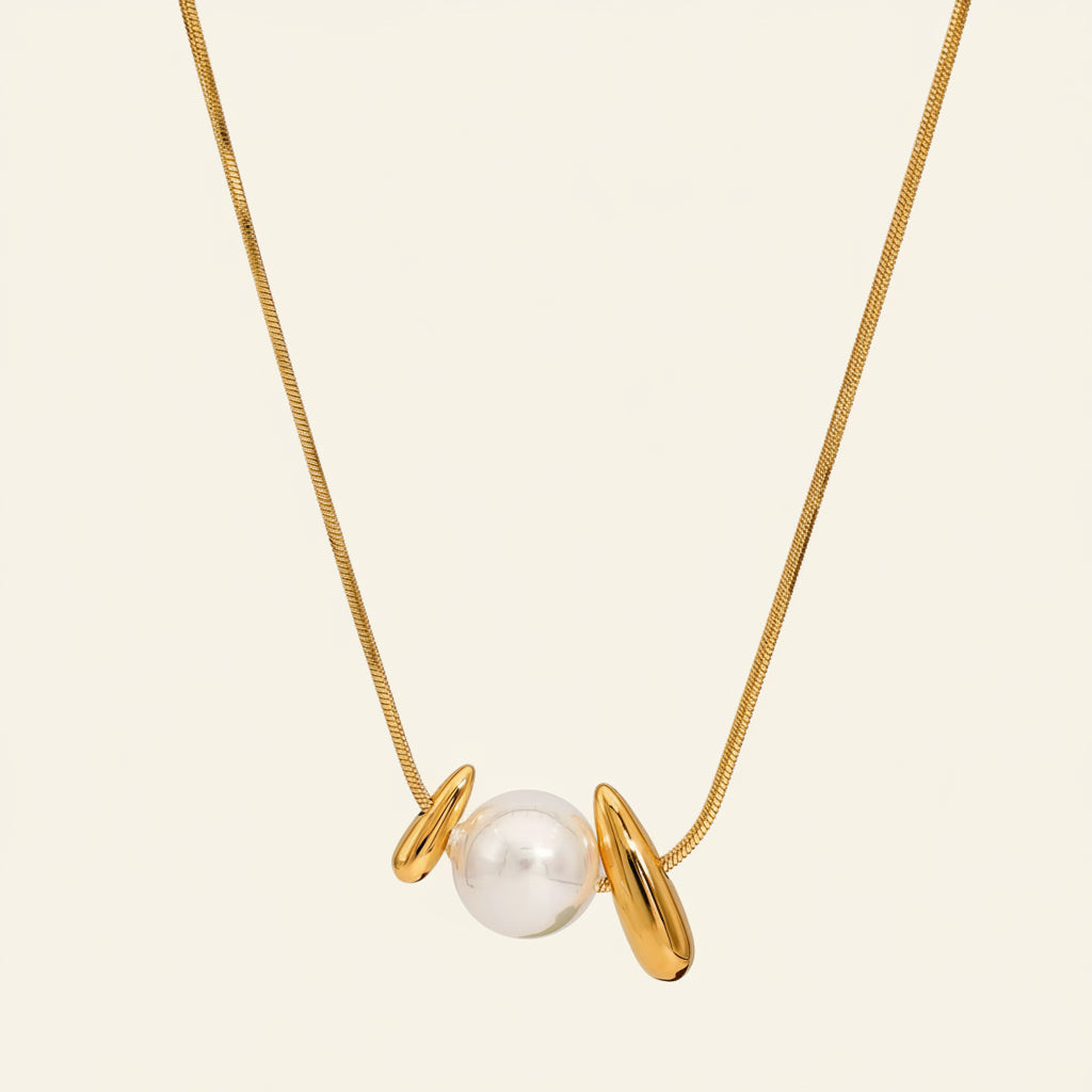 Pearl Embrace Necklace with a central pearl framed by curved metal details in gold finish