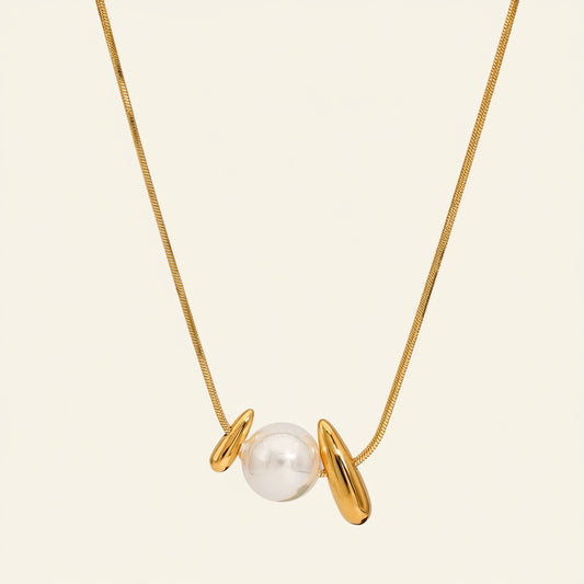 Pearl Embrace Necklace with a central pearl framed by curved metal details in gold finish