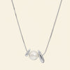 Pearl Embrace Necklace with a central pearl framed by curved metal details in silver finish