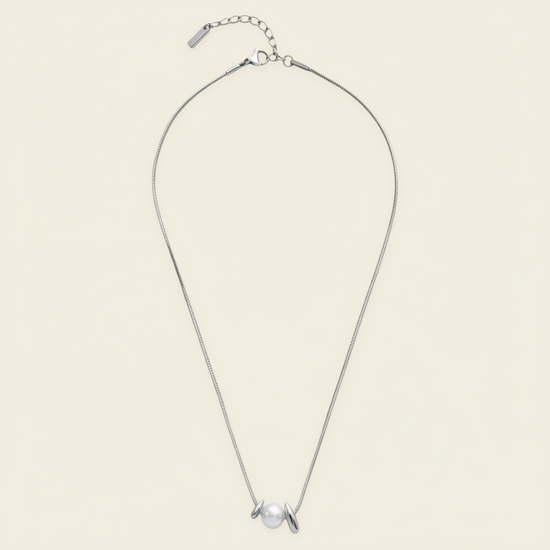 Pearl Embrace Necklace with a central pearl framed by curved metal details in silver finish