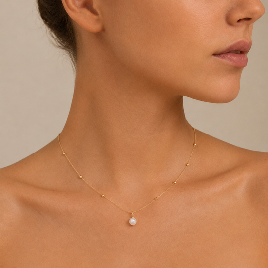 Pearl Trace Necklace worn at the neckline in gold finish