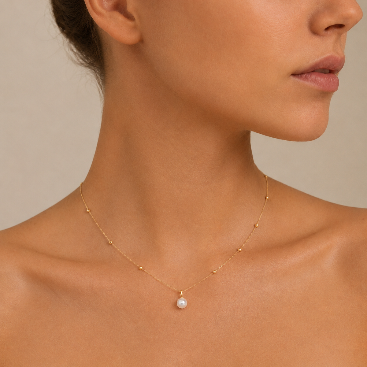 Pearl Trace Necklace worn at the neckline in gold finish