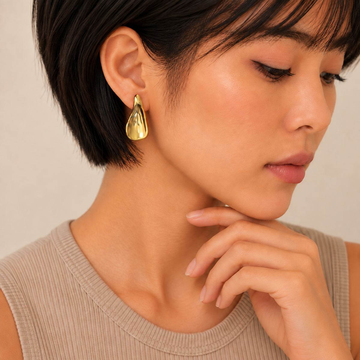 Polished Droplet Earrings worn on the ear in gold finish
