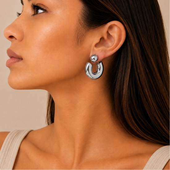 Polished Orbit Earrings worn on the ear in silver finish