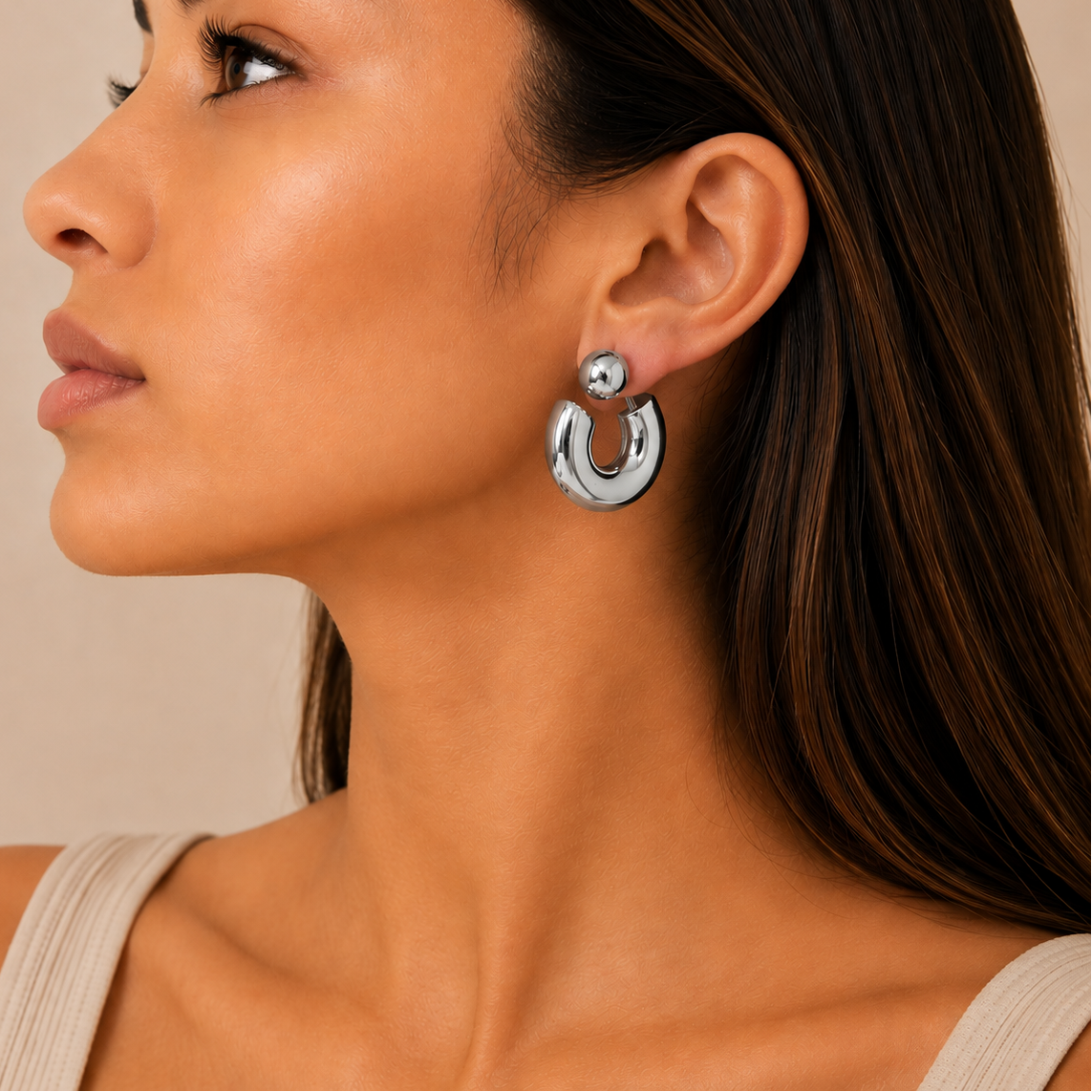 Polished Orbit Earrings worn on the ear in silver finish