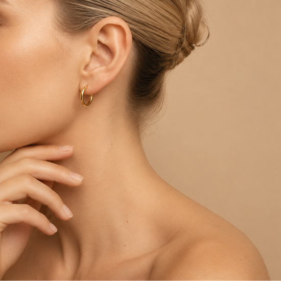 Quiet Arc Earrings worn on the ear in gold finish