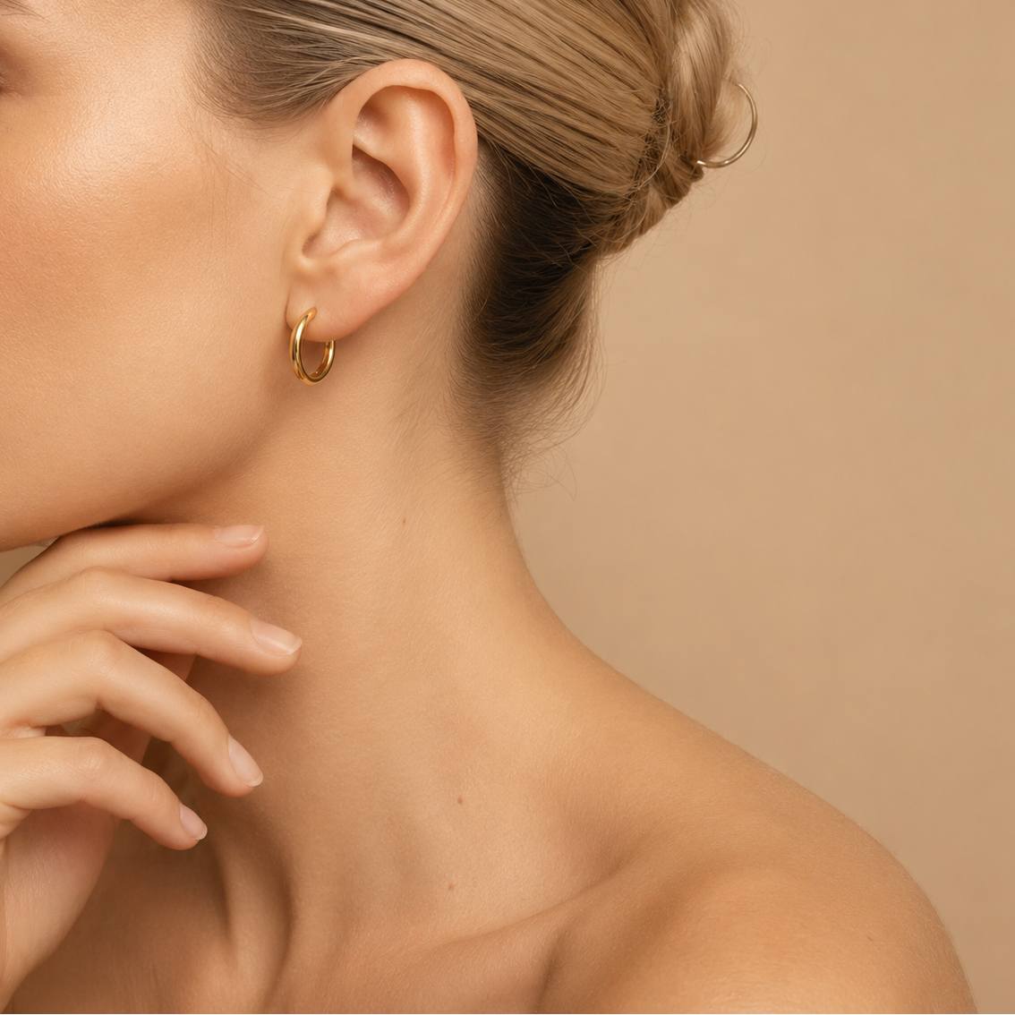 Quiet Arc Earrings worn on the ear in gold finish