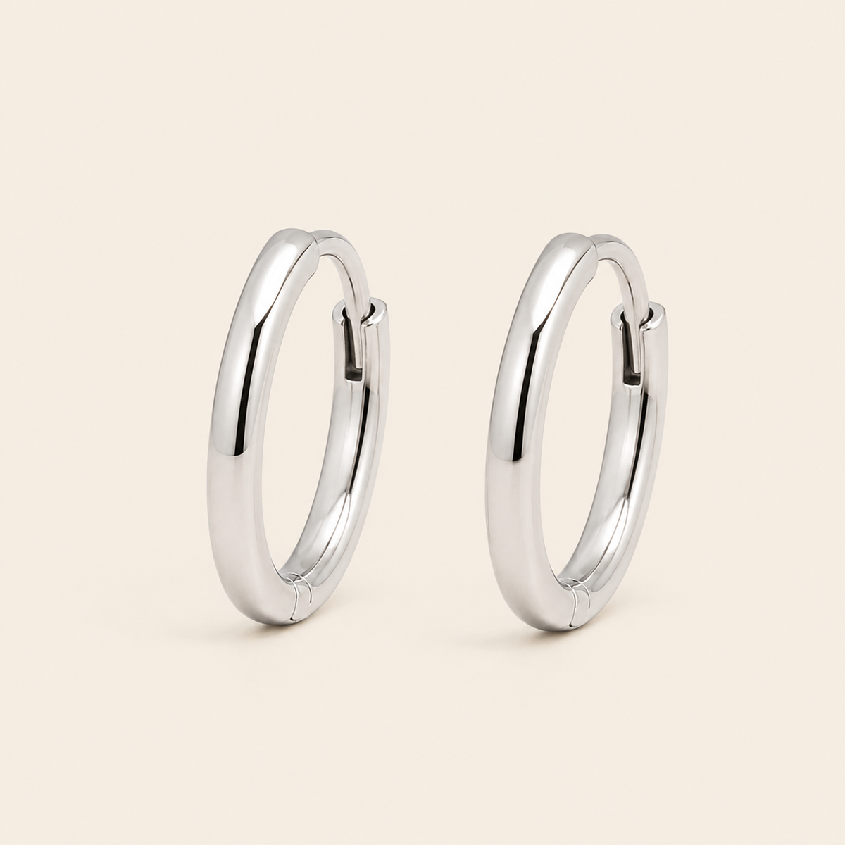 Quiet Arc Earrings with smooth oval hoops in silver finish