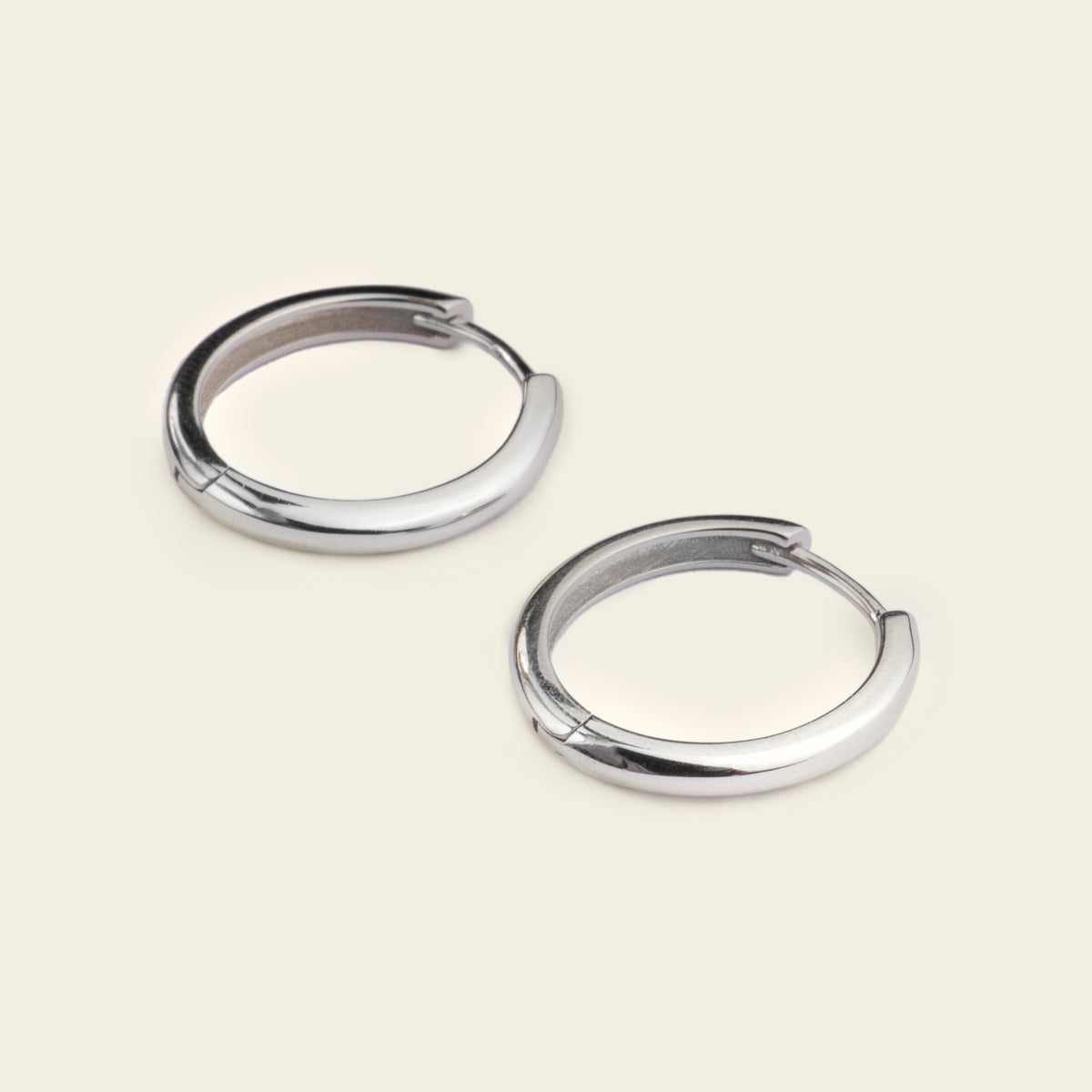 Quiet Arc Earrings with smooth oval hoops in silver finish