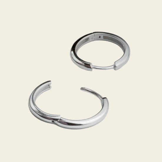 Quiet Arc Earrings with smooth oval hoops in silver finish