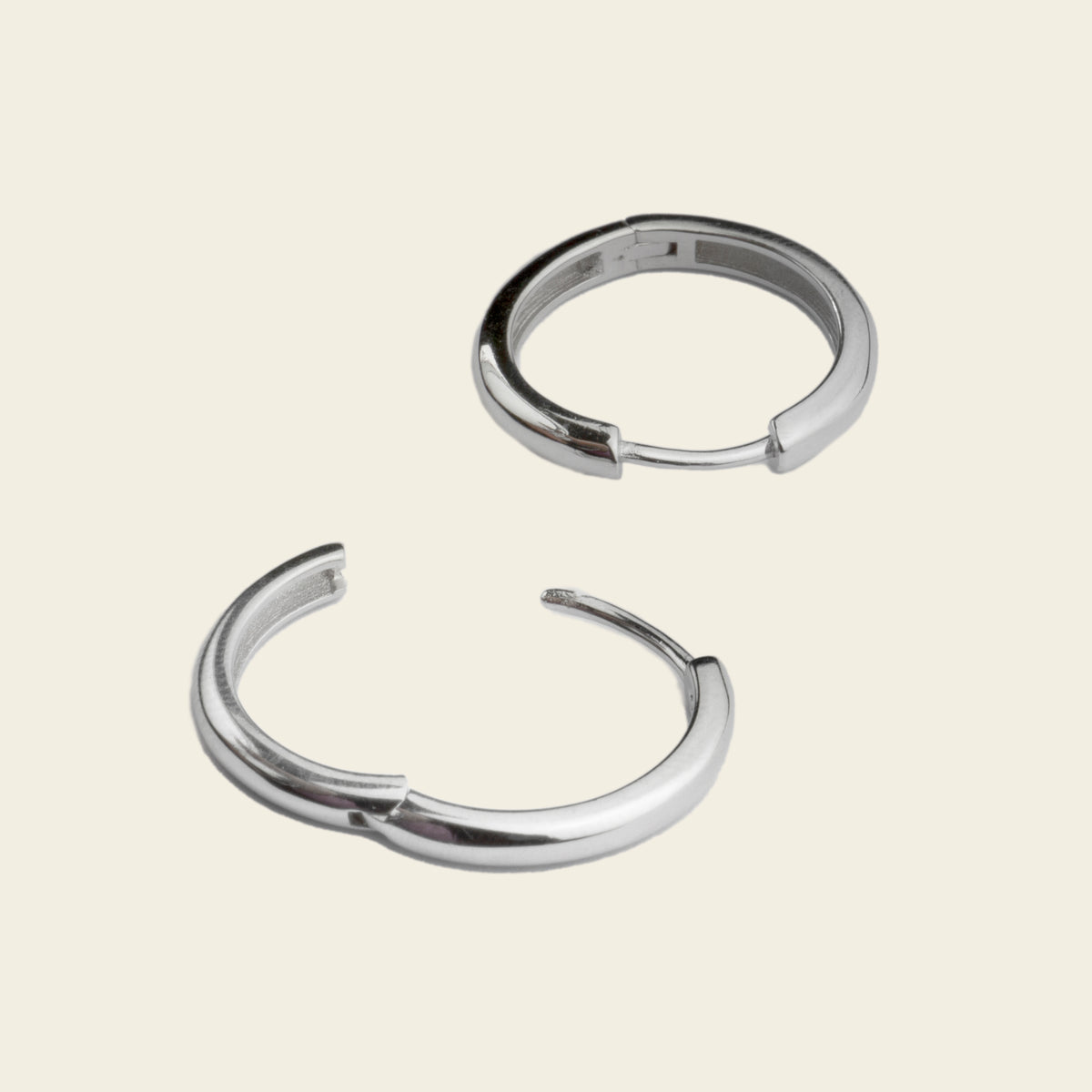Quiet Arc Earrings with smooth oval hoops in silver finish