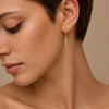 Quiet Edge Earrings worn on the ear in gold finish