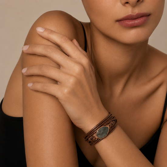 Quiet Ember Bracelet worn on the wrist, with a grey stone centre on layered brown cord