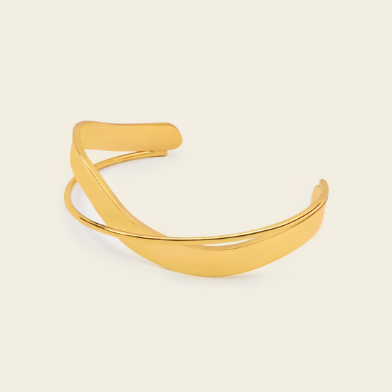 Ribbon Sweep Cuff with a broad open band with overlapping curved lines in gold finish