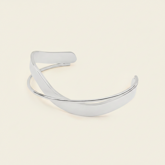 Ribbon Sweep Cuff with a broad open band with overlapping curved lines in gold finish