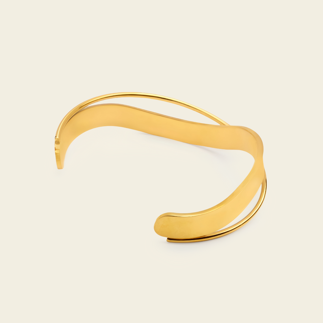 Ribbon Sweep Cuff with a broad open band with overlapping curved lines in gold finish