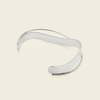 Ribbon Sweep Cuff with a broad open band with overlapping curved lines in gold finish