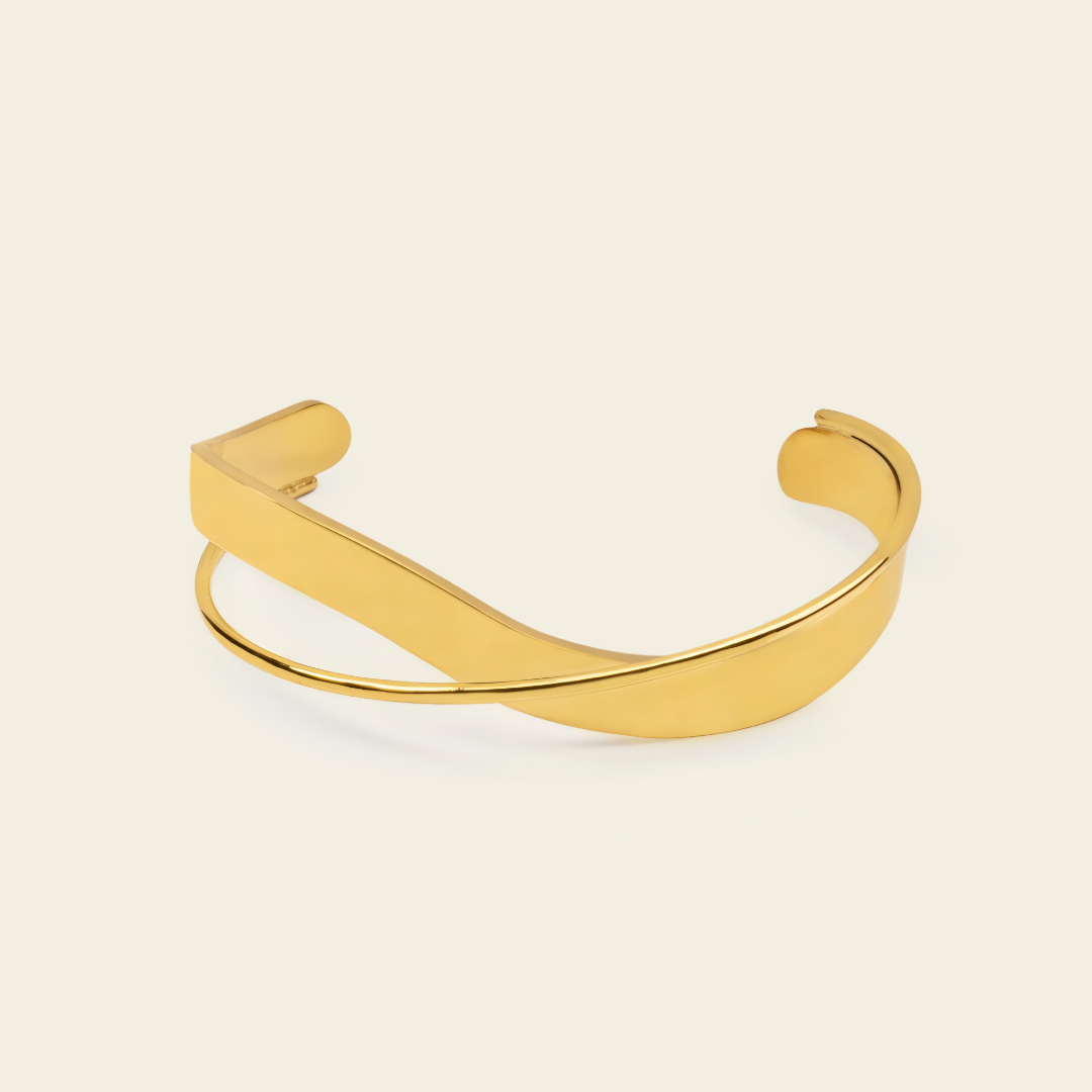 Ribbon Sweep Cuff with a broad open band with overlapping curved lines in gold finish