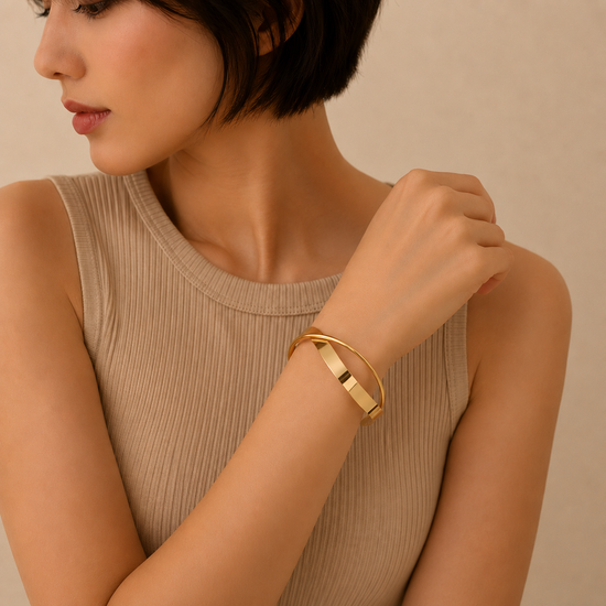 Ribbon Sweep Cuff worn on the wrist in gold finish