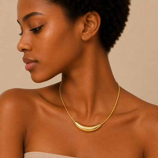 Sculpted Arc Necklace worn at the neckline in gold finish