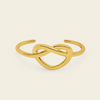 Sculpted Knot Cuff with an open band with a central sculpted knot in gold finish