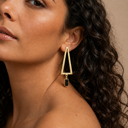 Shadow Frame Earrings worn on the ear, with long triangular frames and dark rectangular drops