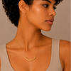 Slender Arc Necklace worn at the neckline in gold finish