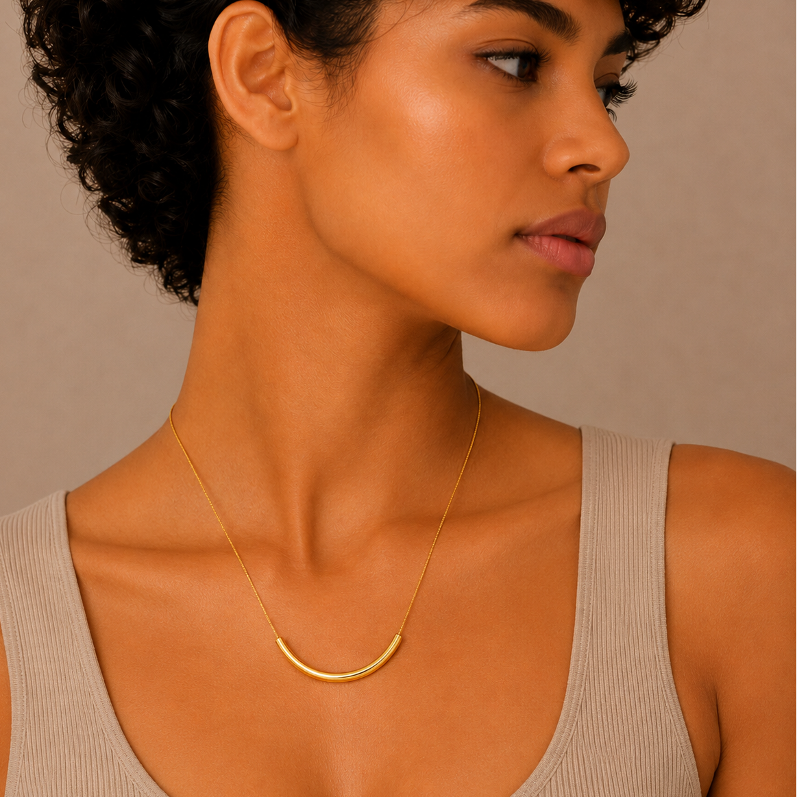 Slender Arc Necklace worn at the neckline in gold finish