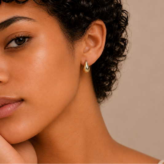 Soft Curve Earrings worn on the ear in gold finish