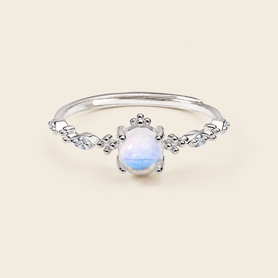 Soft Moon Ring with a pale blue round centre stone and small floral accents in silver finish