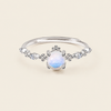 Soft Moon Ring with a pale blue round centre stone and small floral accents in silver finish