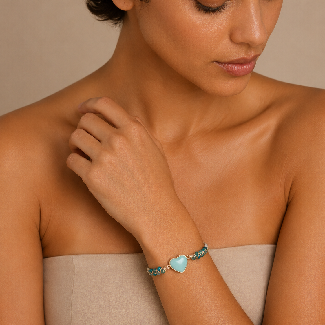 Soft Signal Bracelet worn on the wrist, with turquoise-coloured beads and a pale heart centre