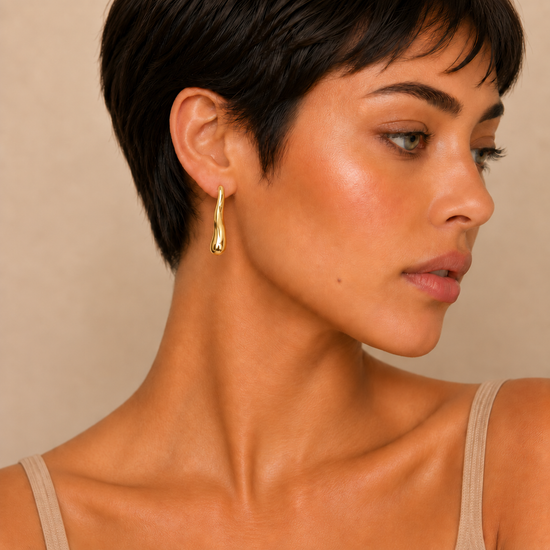 Soft Taper Earrings worn on the ear in gold finish