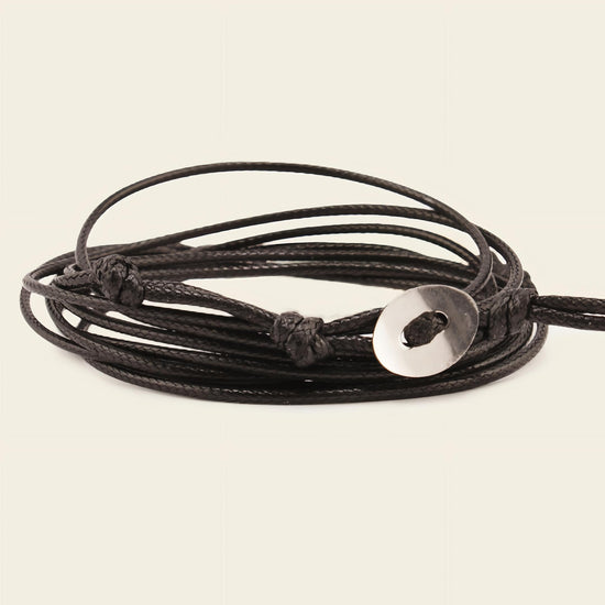 Stillwater Hold Bracelet with a turquoise-coloured stone centre on layered dark cord
