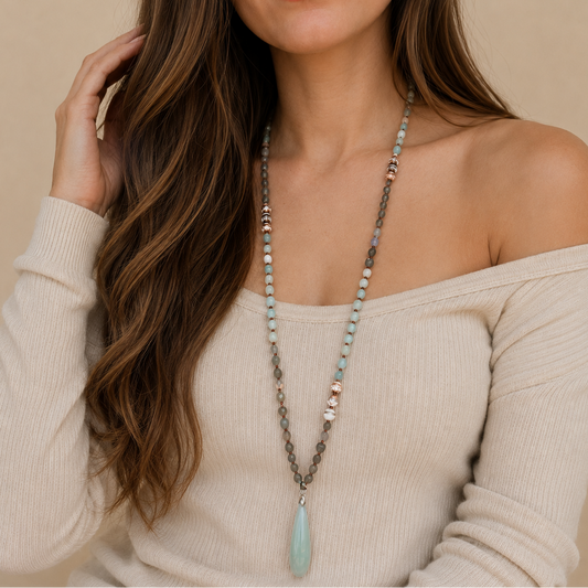Stillwater Thread Necklace worn at the neckline, with pale beads and an elongated pale pendant