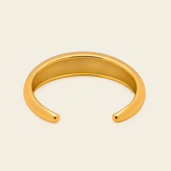 Tapered Arc Cuff with a smooth tapered open band in gold finish