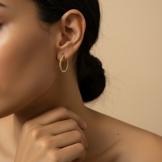 Twist Arc Earrings worn on the ear in gold finish
