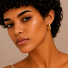Twisted Ribbon Earrings worn on the ear in gold finish