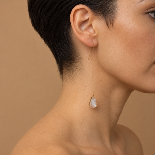 Whisper Drop Earrings worn on the ear, with long fine gold-coloured stems and pale teardrop drops